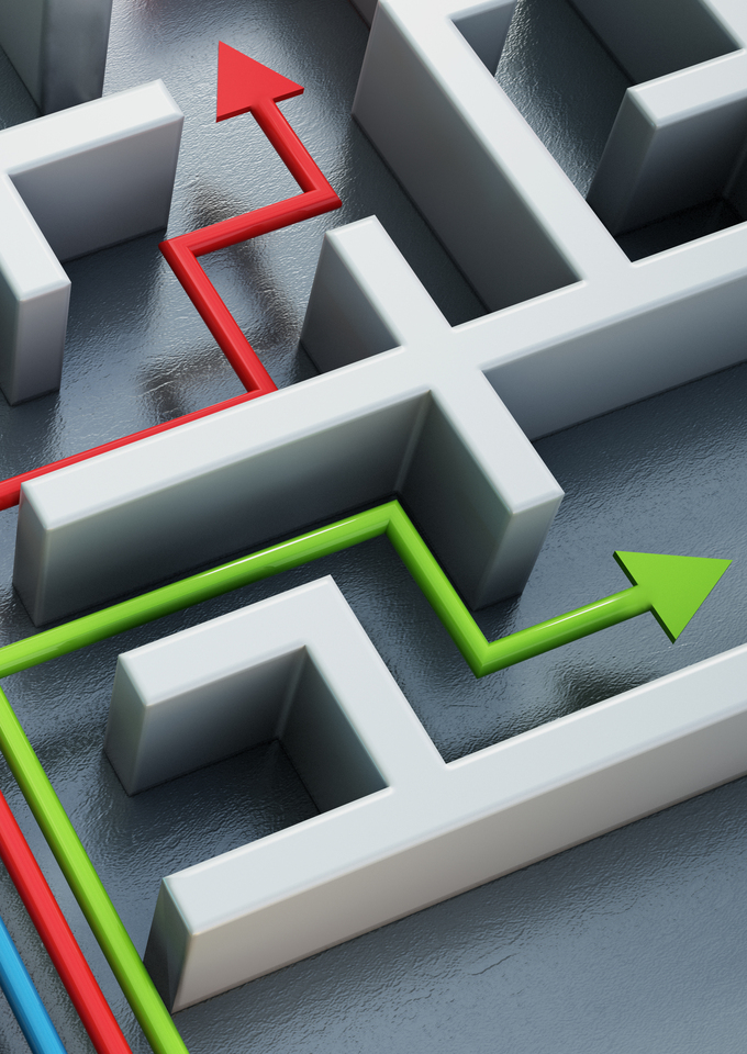 Four colored arrows—blue, yellow, red, and green—navigate different paths through a white 3D maze.